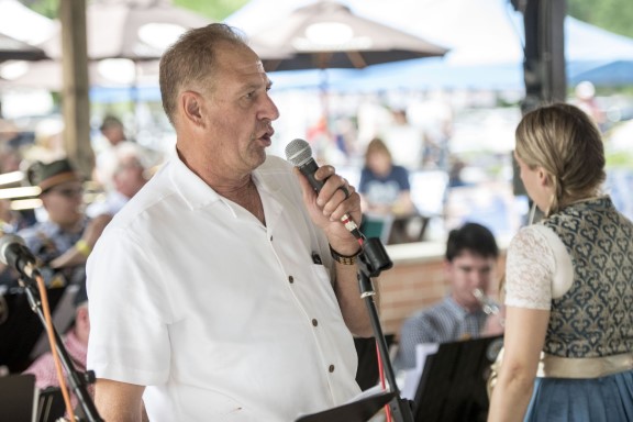 Two singers at a microphone with sheet music