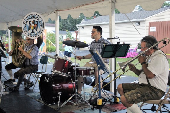 A picture of several musicians, including a trombonist, sousaphonist, tubist, and drummer.